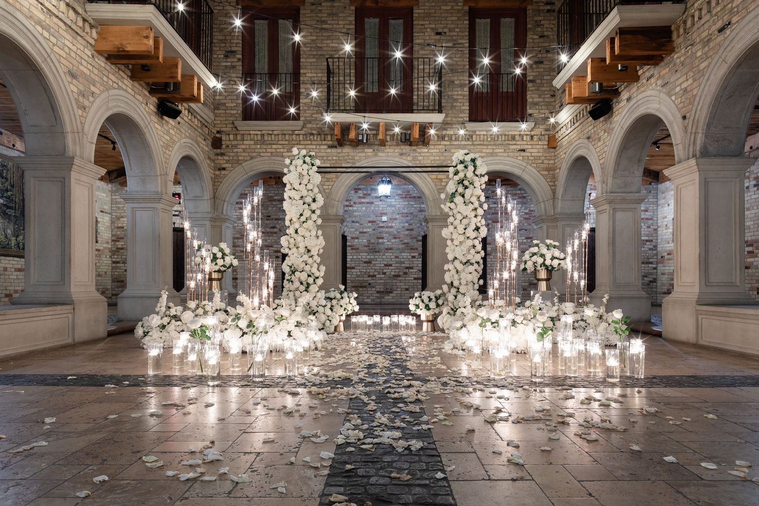 Elegant white marble hall with arched columns and sparkling lights illuminating the grand interior space.
