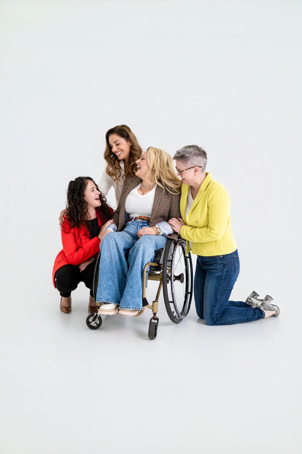 Group of friends sharing joyful moment together with wheelchair user in studio setting.