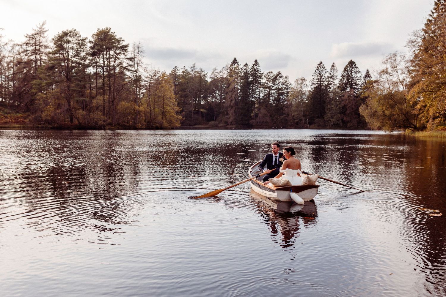 A couple row romantically into the sunset on Knipe Tarn at Gilpin Hotel and Lake House