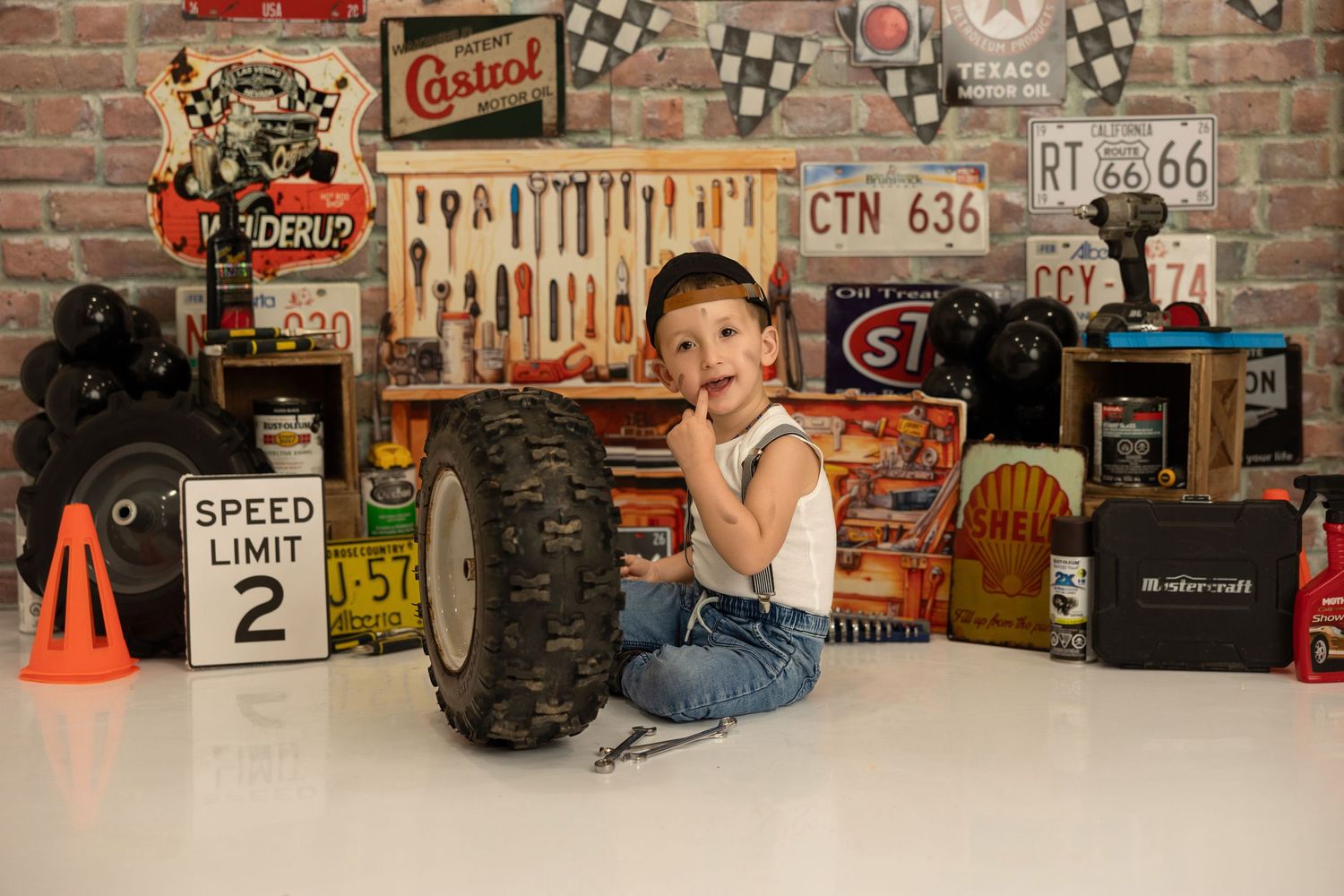 A rustic garage-themed setup with tools and vintage signs on brick wall displaying automotive memorabilia and decor.