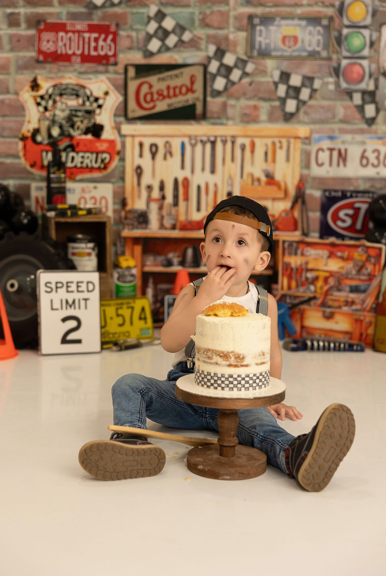 A playful moment captured in a vintage garage setting with checkered racing decor and automotive signs on display.