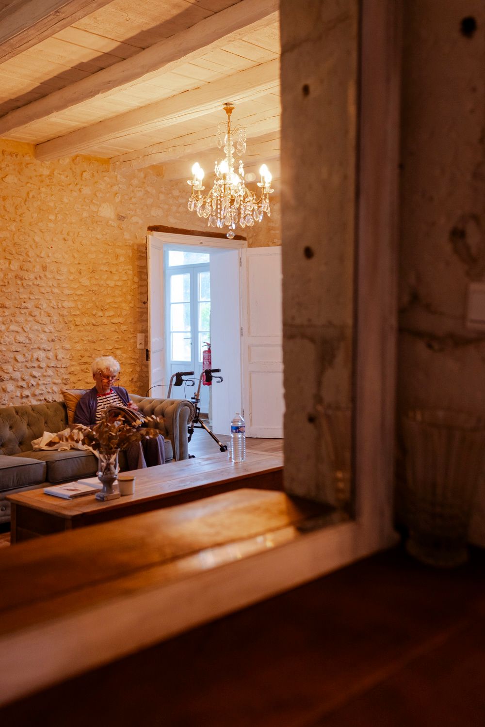 Grand mère patientant dans le salon avant la cérémonie de mariage vue à travers un miroir