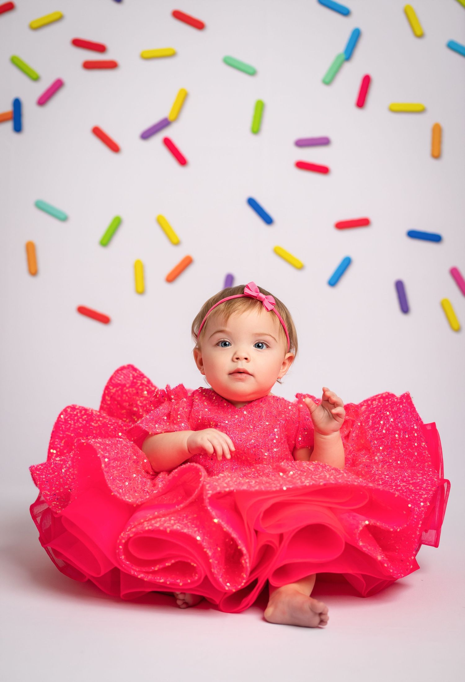 A vibrant hot pink tulle dress with sparkly gold sequins scattered across the fabric.