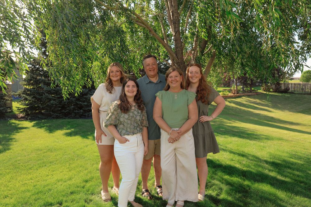 Group portrait on a sunny lawn with green grass and natural summer lighting.