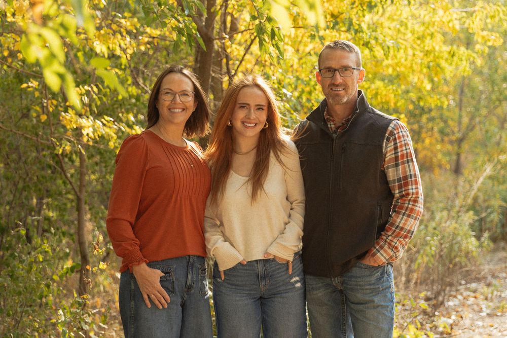 Group portrait session in a park with warm autumn colors and natural lighting.