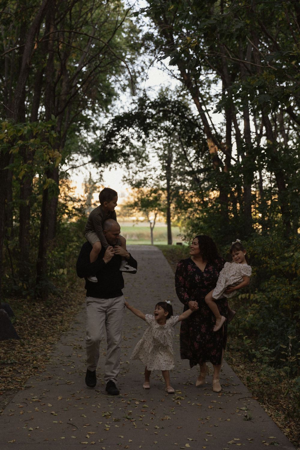 Silhouettes of people playing and posing on a nature trail at dusk.