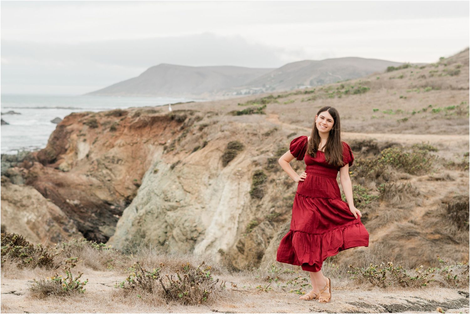 flowing red dress worn by slo high senior for san luis obispo high school senior photos off of highway 1 on bluff trails