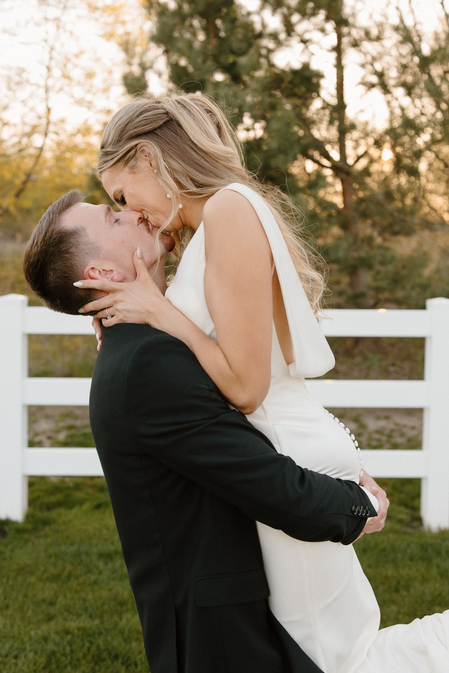 A joyful black and white wedding portrait capturing a candid moment of laughter between newlyweds.