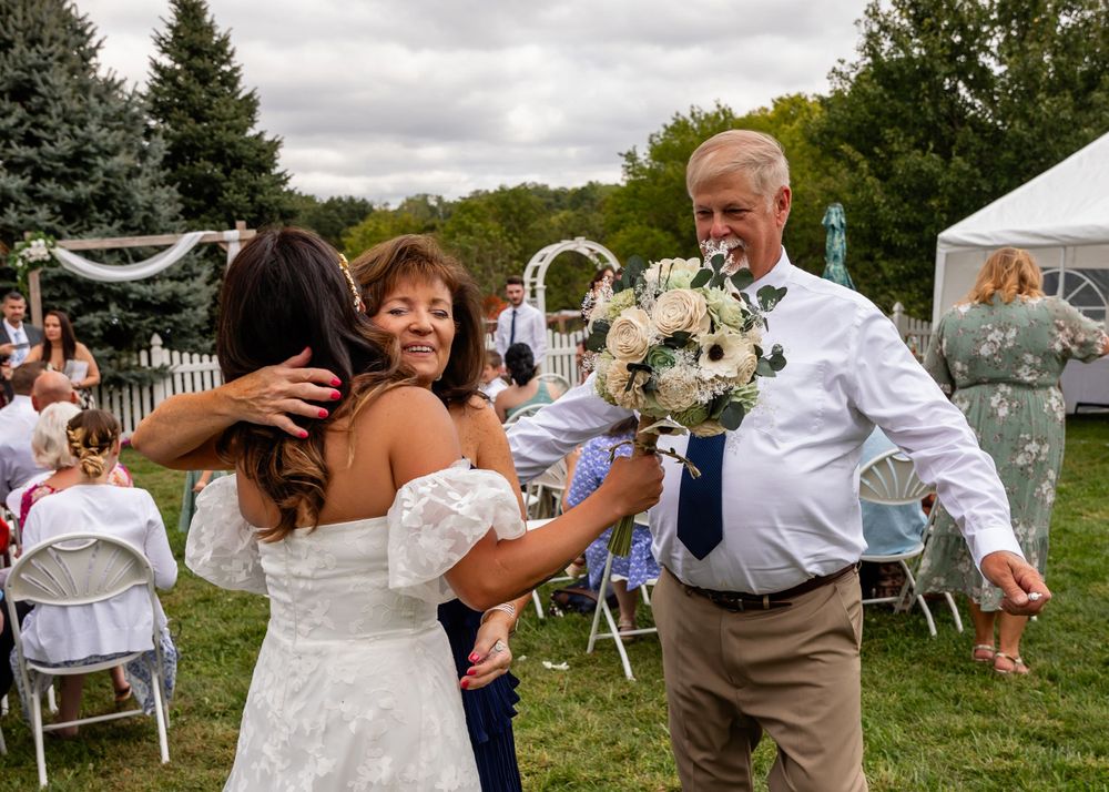 Hugs at backyard wedding garden ceremony in Omaha, Nebraska. - BrightSide Photography