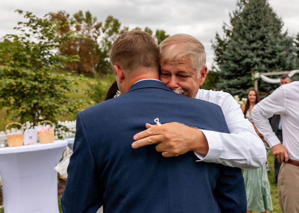 Hugs at backyard wedding garden ceremony in Omaha, Nebraska. - BrightSide Photography