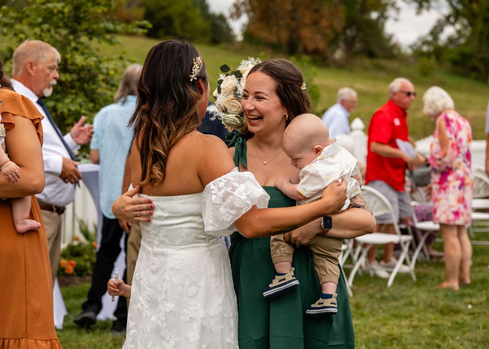Hugs at backyard wedding garden ceremony in Omaha, Nebraska. - BrightSide Photography
