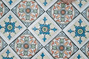 Colorful decorative ceramic tiles in diamond pattern with floral motifs in blue orange and green.