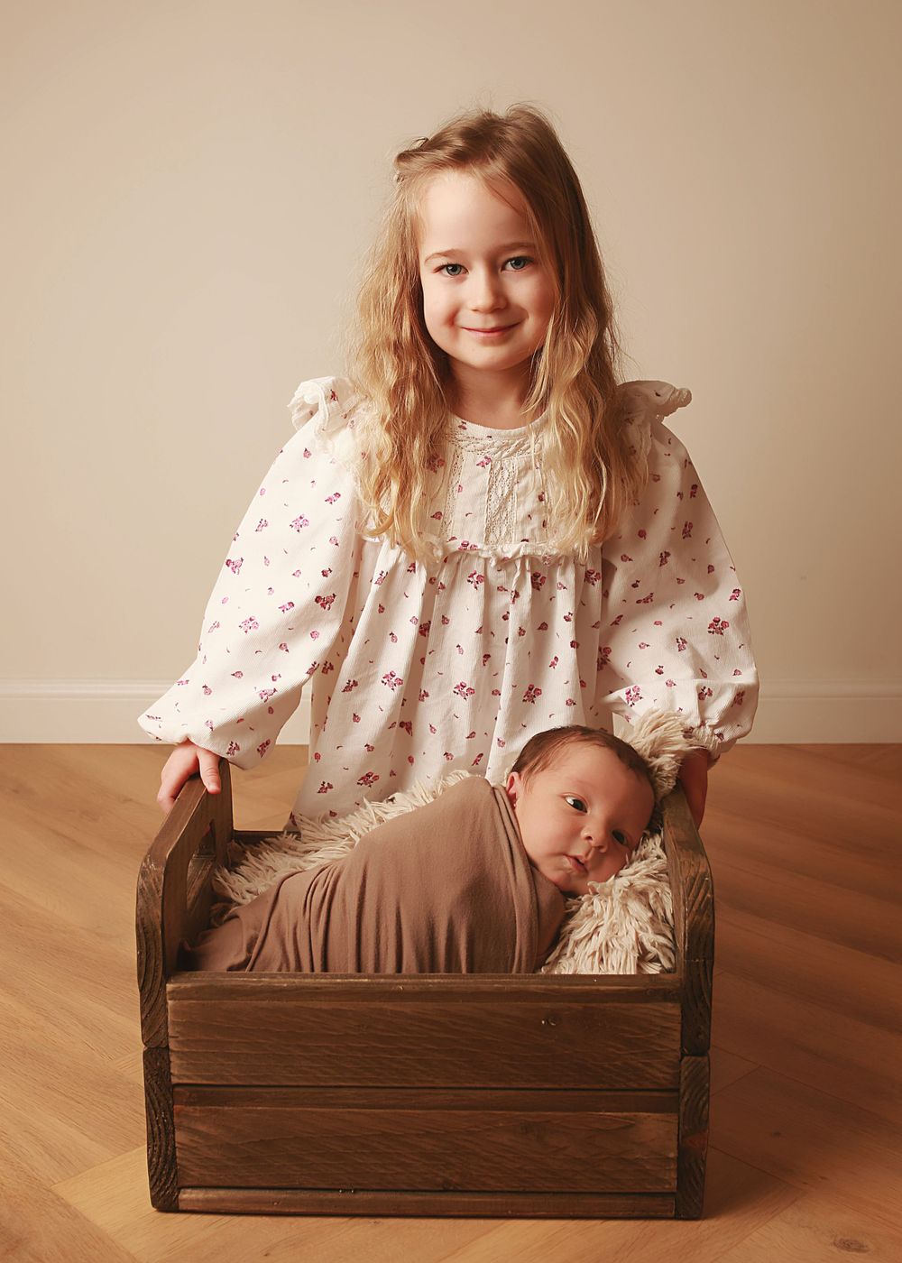 A sweet moment between a sister and her newborn brother, capturing the tenderness and love as they bond during a newborn photography session