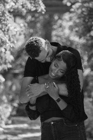 A black and white photo of a couple sharing a loving embrace outdoors.