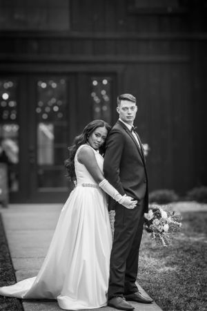 A classic black and white wedding portrait showing a couple in formal attire.
