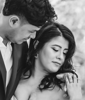 An intimate black and white wedding portrait capturing a tender moment between newlyweds.