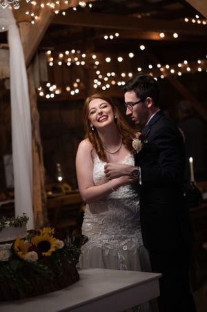 A joyful wedding reception moment under twinkling lights with sunflowers in the background.