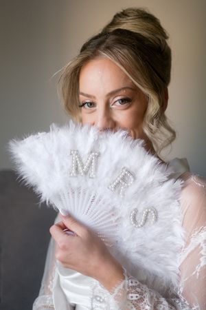 A series of elegant poses with a white feather fan creating a romantic and playful bridal portrait sequence.