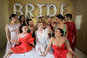 Joyful wedding party in red and white dresses posing together in candid celebratory moments.