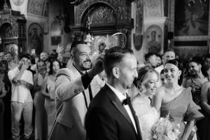 Wedding guests dance and celebrate together on a crowded dance floor during a lively reception celebration.