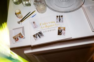 Wedding planning materials including photo albums, stationery samples, and design elements spread across a white surface.