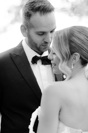 A romantic black and white wedding photo series showing tender moments between newlyweds in formal attire.