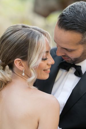A romantic wedding couple shares an intimate moment in formal attire during their special day.