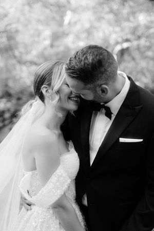 A romantic black and white photo sequence showing a tender kiss between a bride and groom on their wedding day.