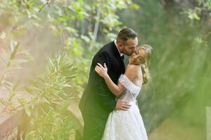 Bride and groom share intimate moments in a romantic outdoor garden setting with soft natural lighting.
