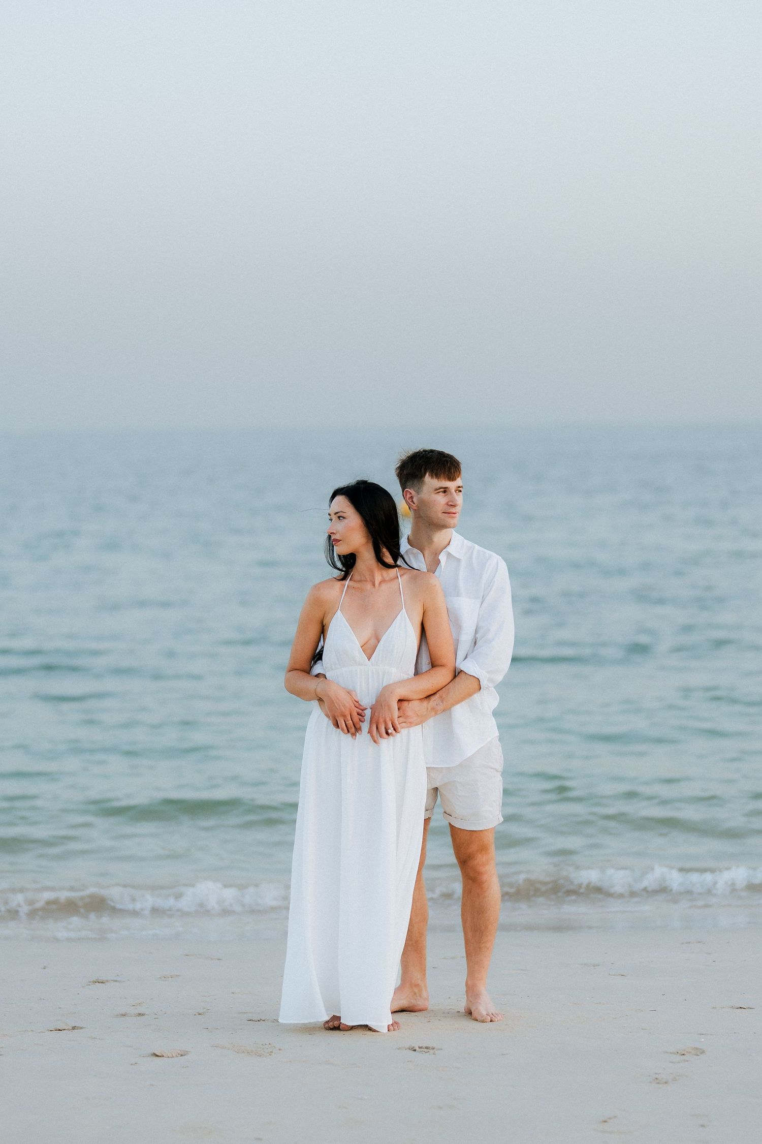 Romantic beach couple photoshoot at sunset with soft ocean backdrop