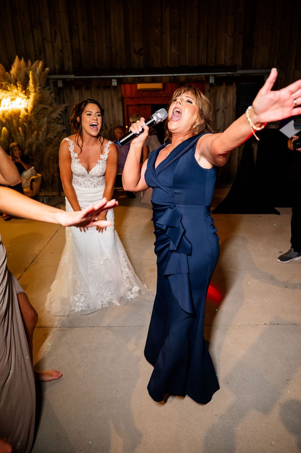 Wedding party members dancing and jumping energetically at an evening reception.