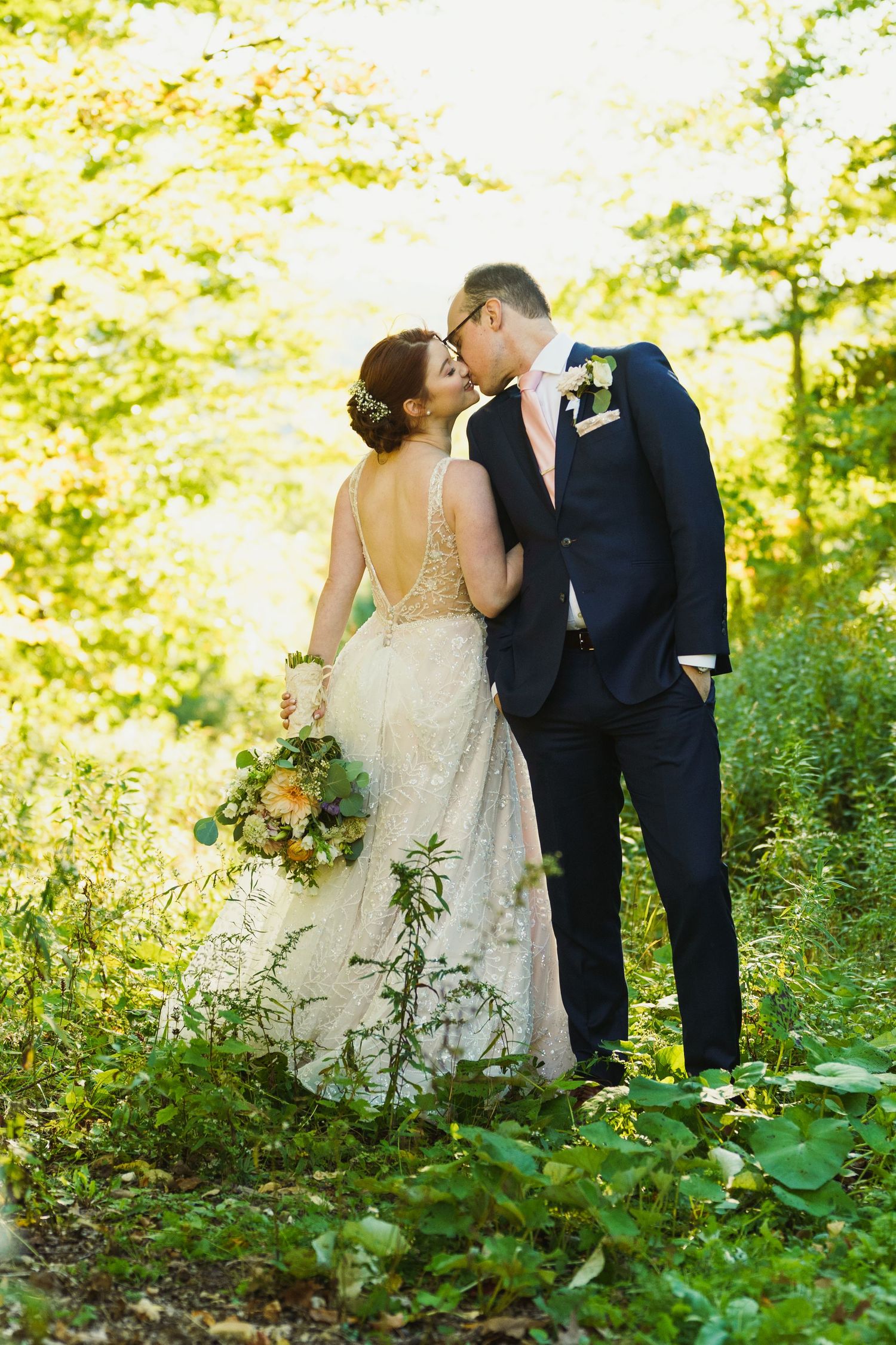 Romantic forest wedding photos with couple among green foliage.
