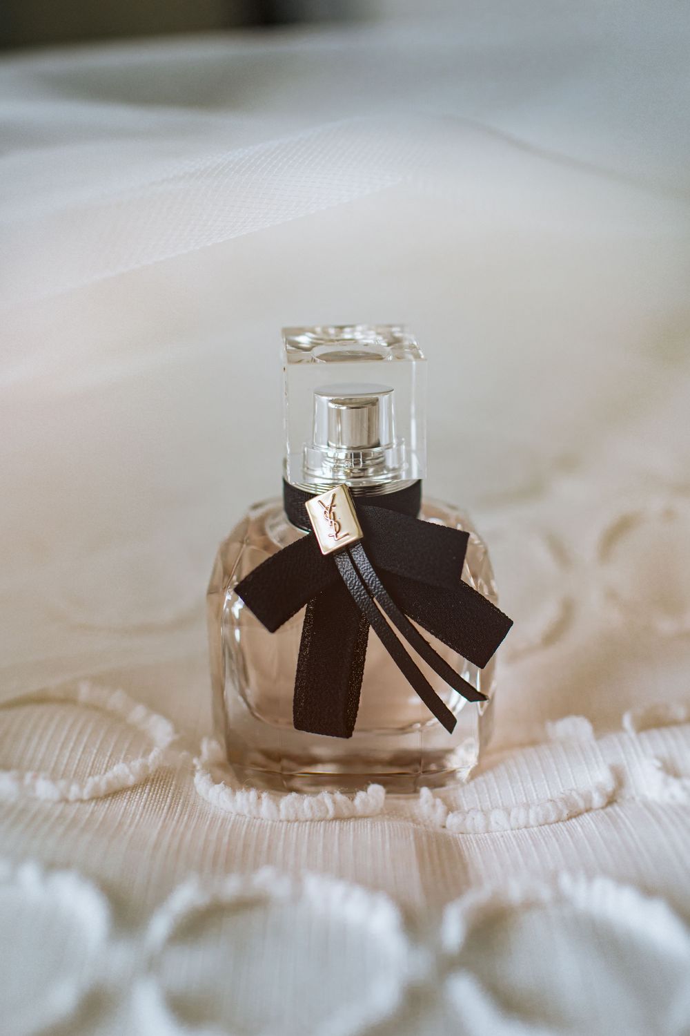 Wedding rings with black ribbons displayed on white lace fabric in an elegant arrangement.