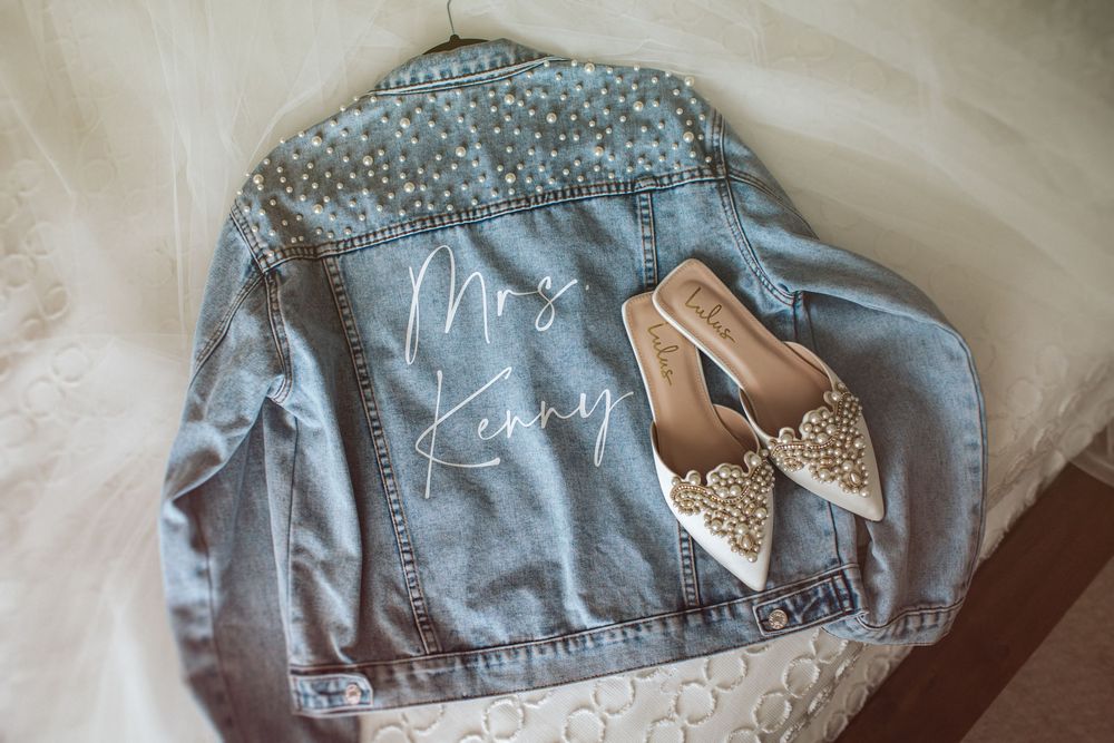 Light blue denim jacket decorated with delicate white lace and pearl embellishments along the collar and edges.