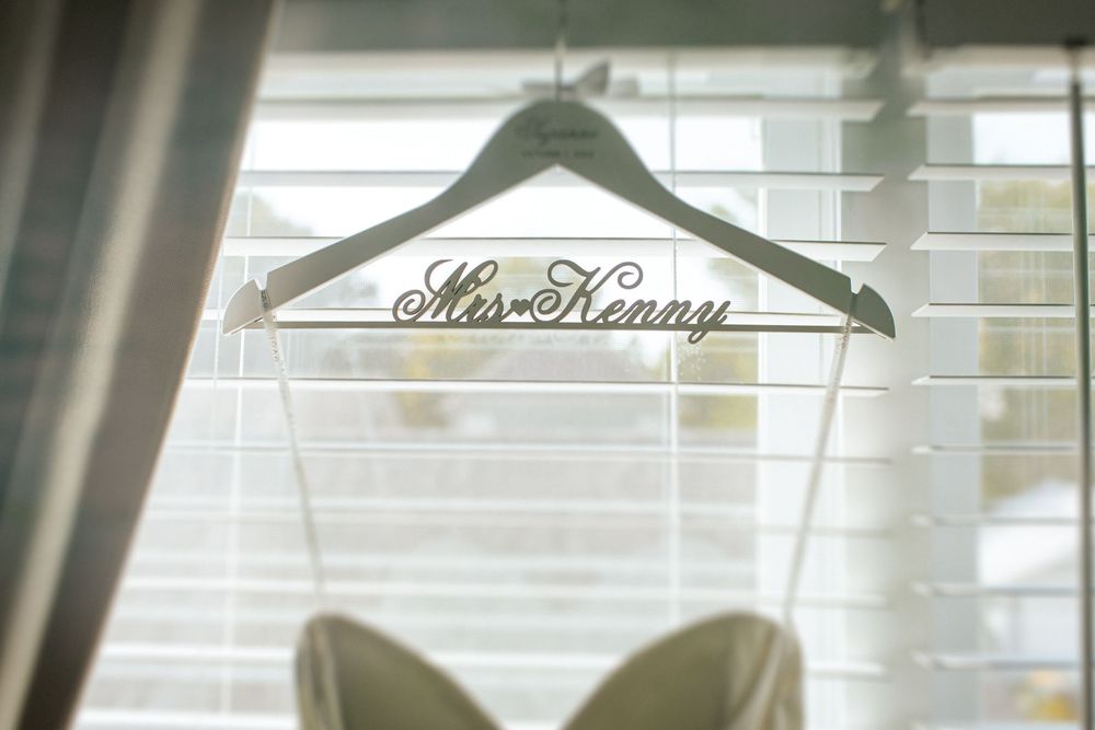 Wooden hangers neatly arranged on a metal clothing rack in a bright room with natural lighting.