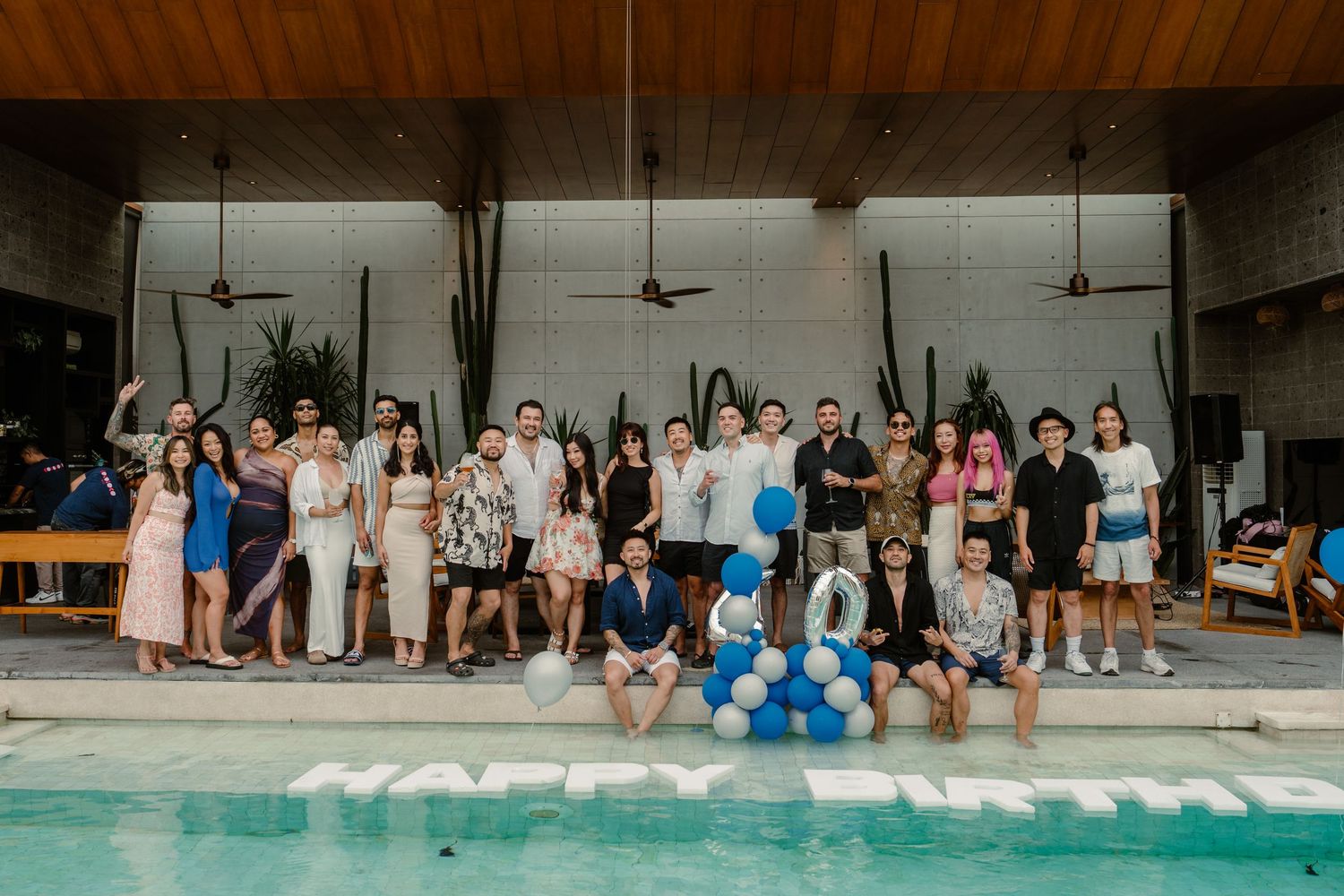 A group of people sitting together on a pool deck during a gathering event.