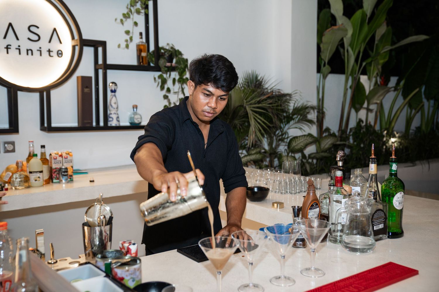 Guests seated at a long dining table enjoy drinks and conversation during an elegant dinner party.