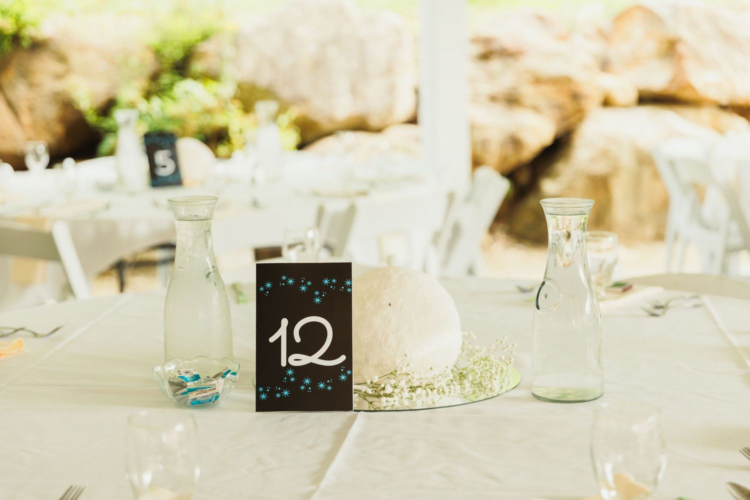 Wedding reception table settings with minimalist white decor and rustic details.