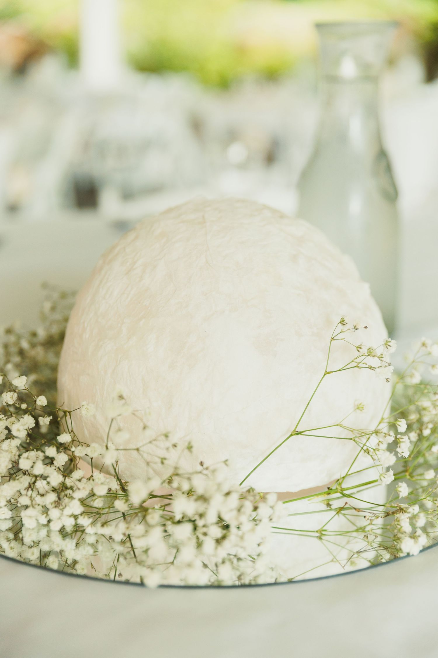 Wedding cake detail shots decorated with delicate baby's breath flowers on white plates.