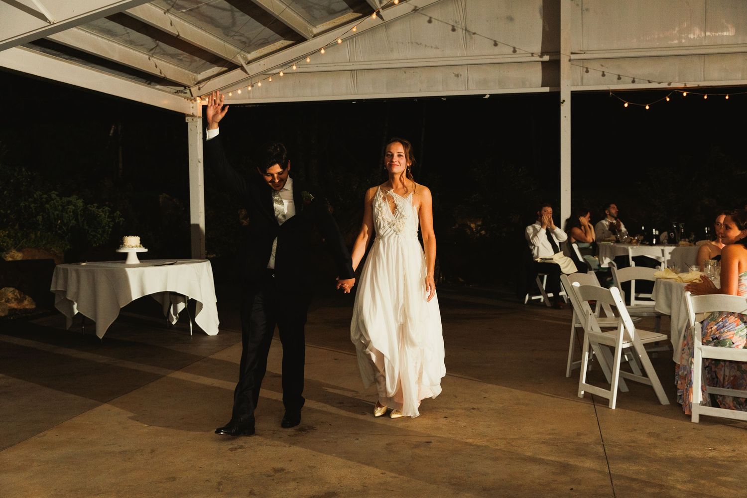 Wedding reception dance floor with dramatic lighting and rustic ceiling beams.