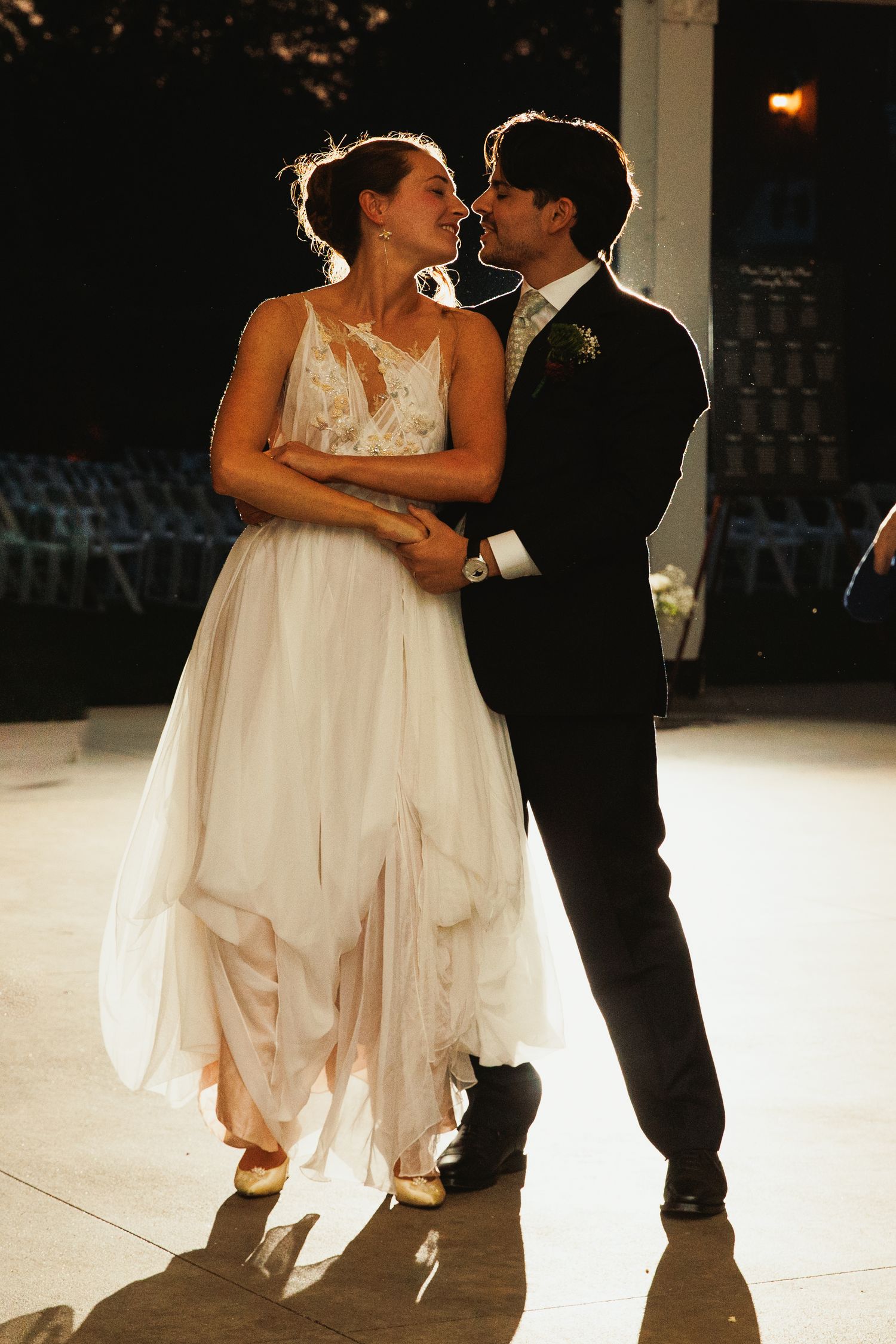 Romantic first dance moment on a softly lit ballroom floor.