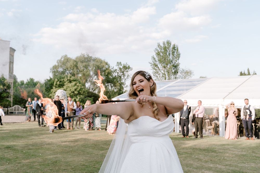 Joyful Worcestershire Bride embraces and dances together on a grassy field during sunset celebrations.