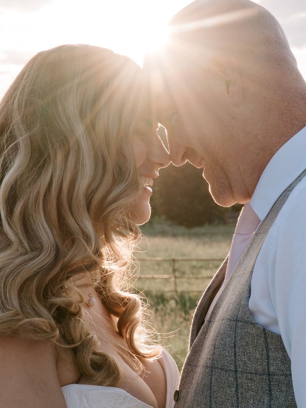 A romantic silhouette of a Worcestershire wedding couple in golden sunlight sharing an intimate moment in a countryside setting.