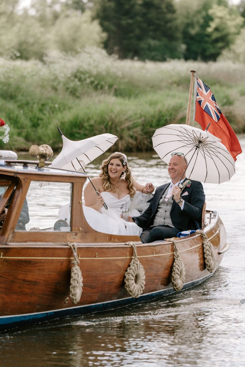 Wedding party rides in wooden boats on river at Worcestershire Wedding Venue
