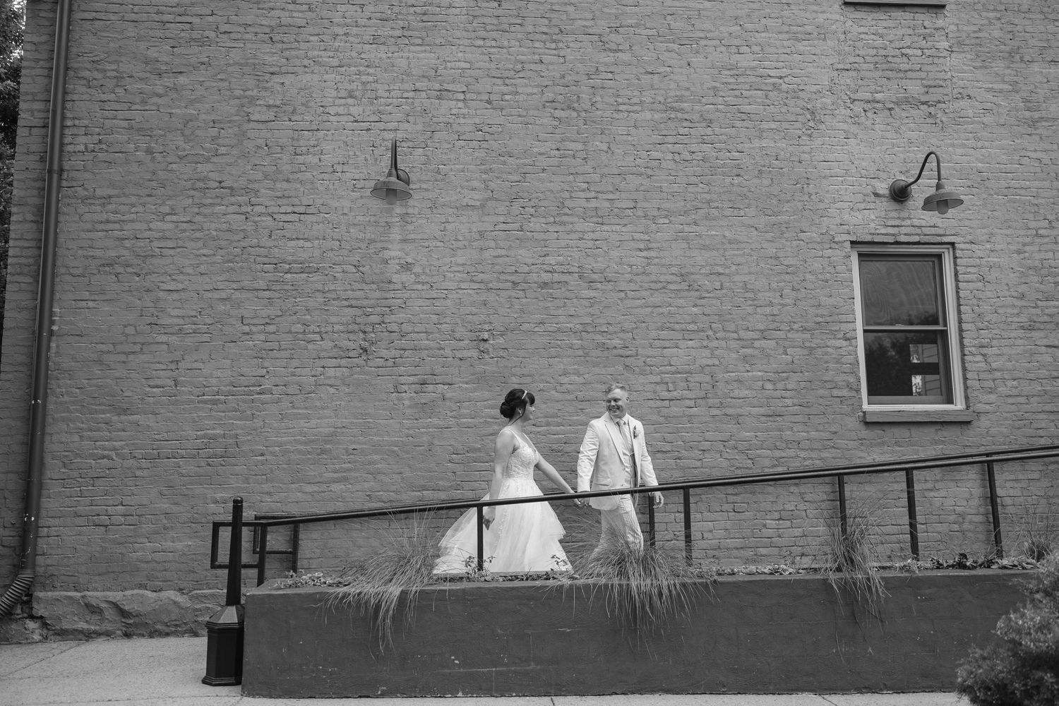 Black and white photograph of a brick building exterior with laundry hanging on clotheslines between walls.