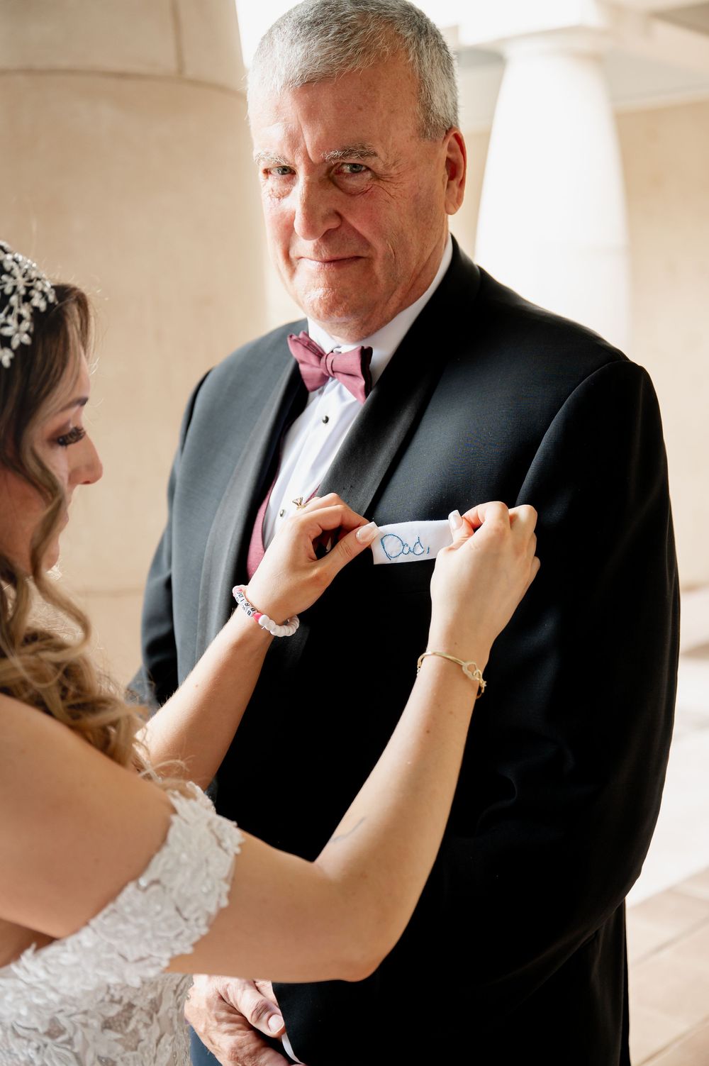 Tender moment shared between bride in lace gown and father during pre-wedding first look.