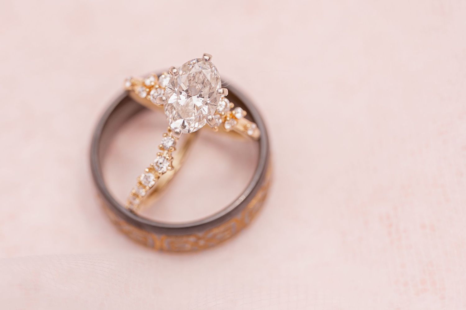 Collection of elegant diamond wedding rings photographed on a pink background.