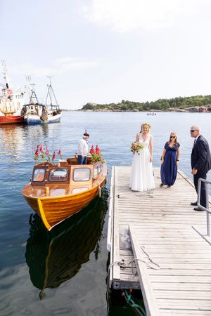 Bruden ankommer vielsen i båt. Hun har akkurat kommet opp på brygga.