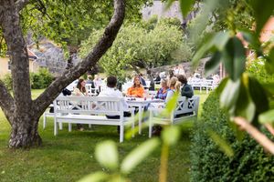 Øyeblikksbilde av gjester som er samlet seg i hagen. Mingling før bryllupsmiddag.