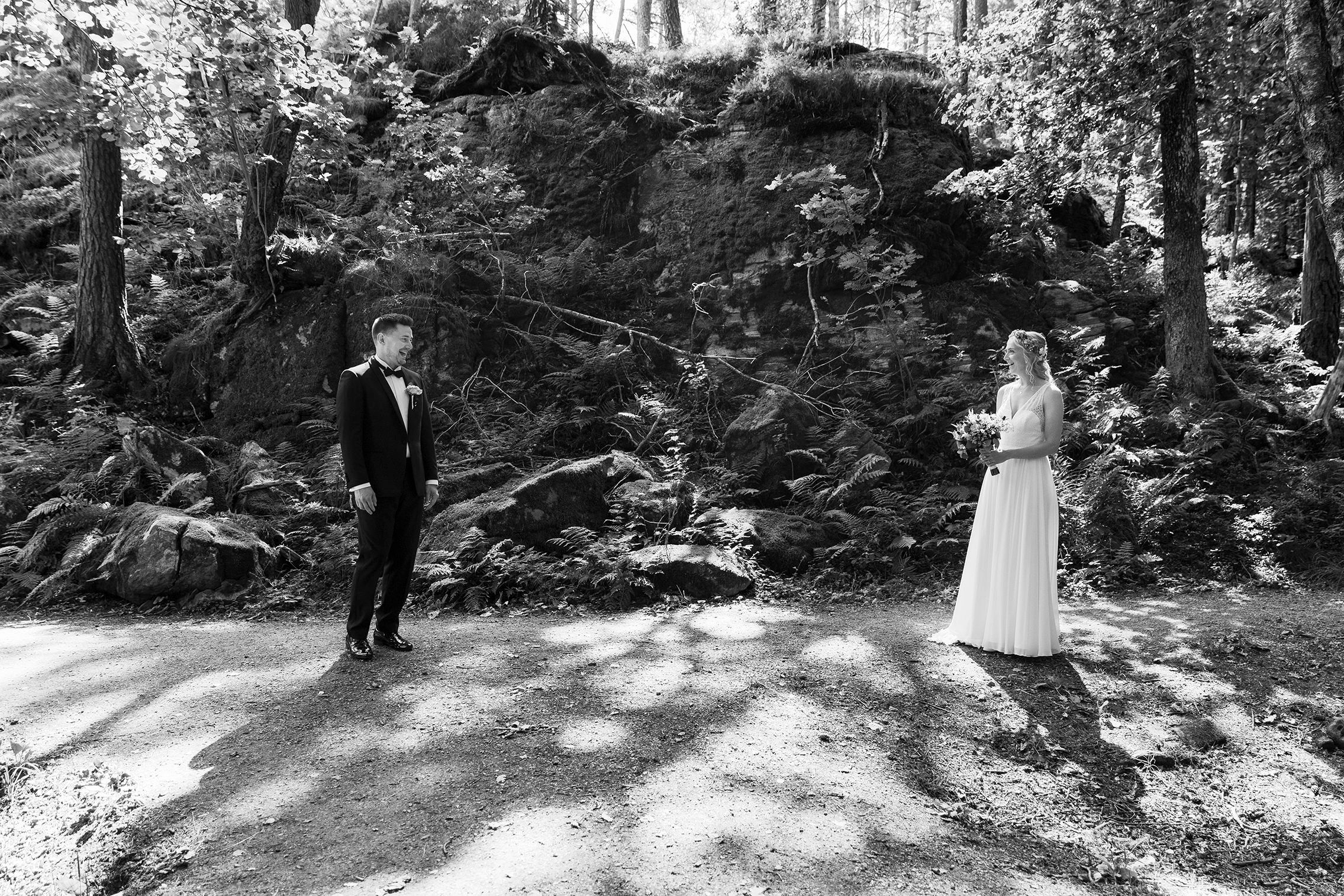 First look i skogen. Brudgommen har akkurat snudd seg og ser bruden. Han ser glad og litt overasket ut